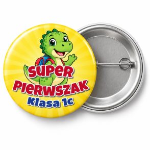 Przypinka Super Pierwszak z Nazwą Klasy Dinozaur: przypinka na pasowanie pierwszoklasisty z napisem Super Pierwszak oraz polem klasa (np. Klasa 1c) – przód i aluminiowy tył z agrafką