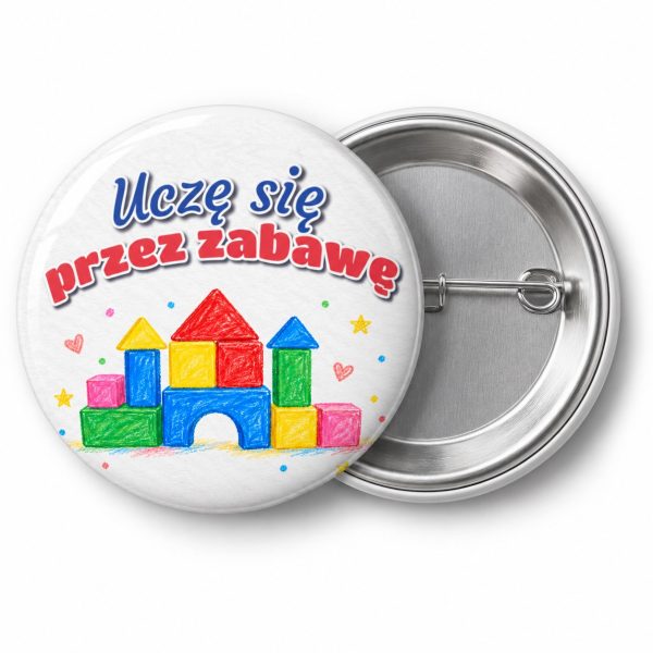 Przypinka Uczę Się przez Zabawę Kredkowe Klocki: przypinka na pasowanie na przedszkolaka z napisem Uczę się przez zabawę – przód i aluminiowy tył z agrafką